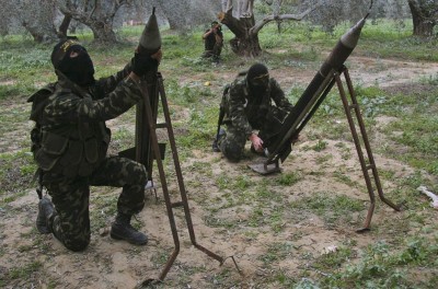 Masked Palestinian militants from Islamic Jihad place homemade rockets before later firing them into Israel on the outskirts of Gaza City,